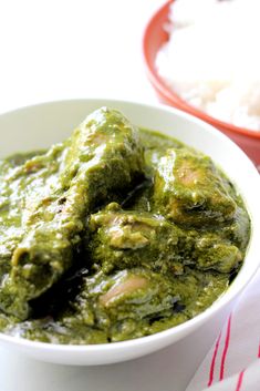 a bowl filled with green food next to rice