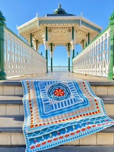 a blue and white blanket sitting on top of a stone steps next to a gazebo