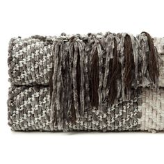 a gray and white clutch bag with fringes on the front, sitting against a white background