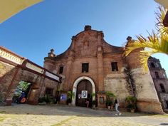 an old building with people walking around it