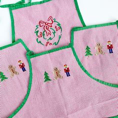 three pink and green aprons with christmas decorations on them