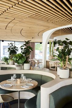 the interior of a restaurant with potted plants