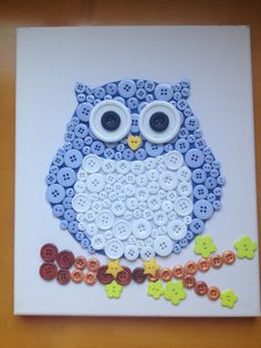 an owl made out of buttons sitting on top of a table