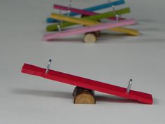 three wooden pegs with colored clothes pins attached to them