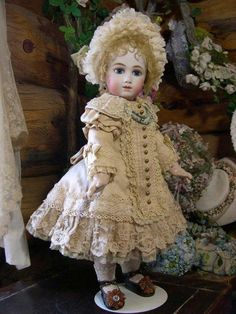 an antique doll is standing on a table