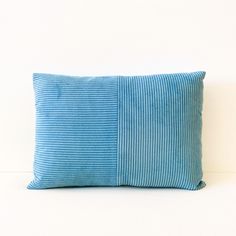 a blue striped pillow sitting on top of a white floor