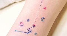 a person with a tattoo on their arm that has stars and planets drawn on it