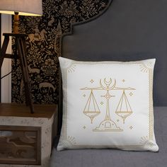 a white pillow sitting on top of a bed next to a night stand and lamp