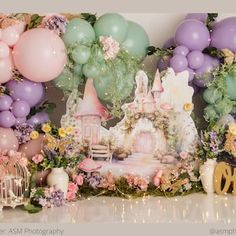 a backdrop with balloons, flowers and a castle