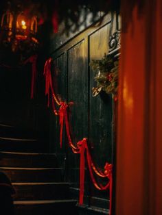 red ribbon hanging on the door to a dark room with stairs and lights in the background