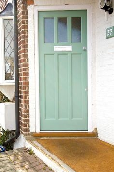 a green front door on a white brick house