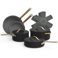 an assortment of black pots and pans with gold handles, on a white background