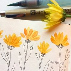 an open notebook with yellow flowers on it and two markers next to the book,