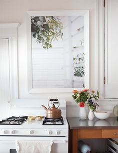 a white stove top oven sitting inside of a kitchen next to a wall mounted mirror