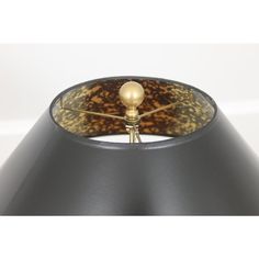 a black lamp with a gold ball on it's end and a brown shade