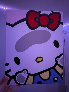 someone is holding up a painting with hello kitty on it