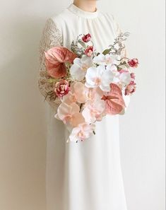 a woman in a white dress holding a bouquet of flowers