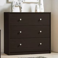 a brown dresser with white knobs and drawers in front of a framed giraffe