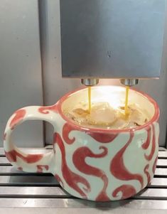 a coffee cup with two candles in it