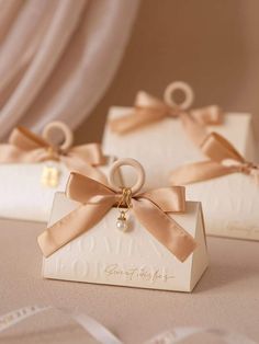 two small white boxes with bows on them