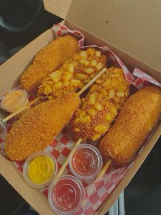 an open box filled with fried food and condiments next to ketchup