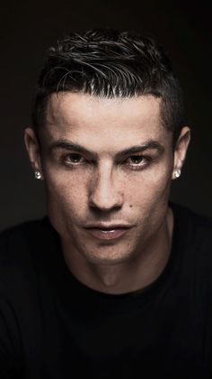 a man with black hair and piercings looks at the camera while wearing a black shirt