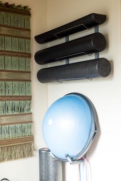 an exercise ball sits on top of a pole in front of a wall mounted yoga mat