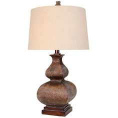 a lamp that is sitting on top of a wooden base with a white shade over it