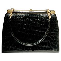 Classic vintage black alligator handbag features gold tone hardware and a single handle attached to the frame with a 5-link chain on each end. The interior is black leather with side compartments and fabric tag marked "Marshall Field & Company", the Chicago department store that retailed it. Very nice vintage condition. Alligator Handbags, Black Alligator, Fabric Tags, Classic Vintage, Fashion Handbags, Vintage Stil, Alligator, Vintage Black, 1960s