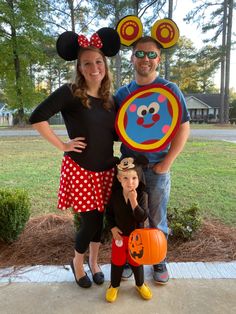 a man, woman and child dressed up in mickey mouse costumes