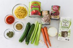 the ingredients to make this soup are laid out on top of a white surface, including carrots, celery, onions, beans, and rice