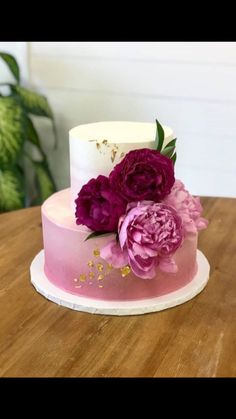 a pink and white cake with flowers on top