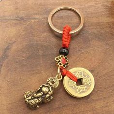 a keychain with two charms attached to it on a wooden table next to a bottle opener