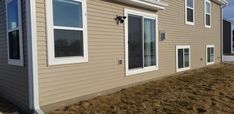 a tan house with white trim and windows