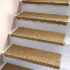 a set of beige carpeted stairs with white handrails