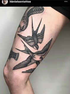 a woman's leg with two birds on it and an arrow in the middle