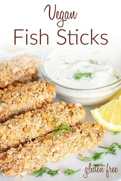 vegan fish sticks on a white plate with lemon wedges and yogurt