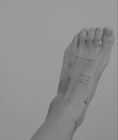 a black and white photo of a person's foot with writing on the side