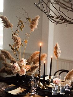 the table is set with candles, flowers and other things to decorate it for dinner