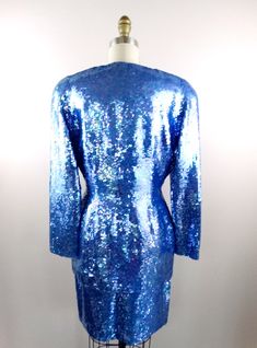 "This is an EXQUISITE hand sewn sequin dress and jacket! This ensemble is fully embellished with iridescent bright blue sequins. It's in perfect condition! Jacket Bust - 38/40\" Jacket Waist - 30\" Jacket Length - 29\" Skirt Waist - 28\" Skirt Hips - 40\" Skirt Length - 20\" This dress comes from a pet-free and smoke-free home. If you would like more info or have any questions, please don't hesitate to ask!" Glamorous Fitted Blue Sequin Fabric, Elegant Fitted Iridescent Dress, Fitted Blue Sequin Fabric With Contrast, Fitted Iridescent Evening Dress, Iridescent Fitted Evening Dress, Fitted Iridescent Dress For Evening, Blue Sequin Dress For Festive Occasions, Blue Sequined Dresses For Festive Occasions, Festive Blue Sequin Dress