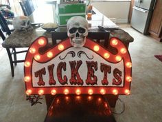 a lighted sign that says tickets with a skull on it