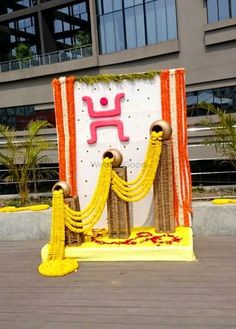 a decorated stage with yellow and red decorations on the ground in front of a building