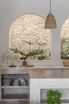 an open kitchen with stone walls and plants