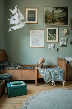 a child's room with green walls and pictures on the wall, including a bed