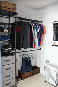 an organized closet with clothes hanging on the rails and shoes in baskets next to it