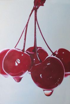 three cherries hanging from a branch with water droplets on them in front of a white background