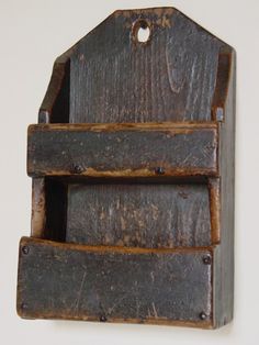 an old wooden shelf hanging on the wall with holes in it's bottom section