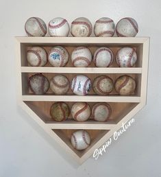 a wooden shelf filled with baseballs on top of a white wall