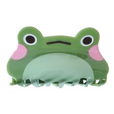 a green and pink frog hair brush with eyes on it's head, sitting in front of a white background