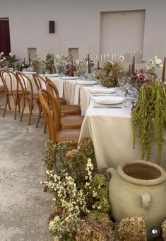 the table is set with flowers and vases for an elegant dinner or party event